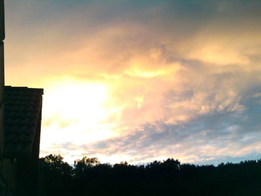 Spätsommerlicher Sonnenuntergang vor dem Haus mit prächtigem Farbenspiel am Himmel